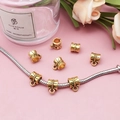 Detailed close-up of an antique gold spacer bead with embossed texture on a silver chain - Vintage Stripe Embossed Style (14334)