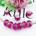 Macro view of faceted magenta beads with silver cores on a metal snake chain bracelet - Rose Red Green Gradient
