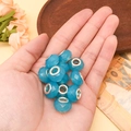 Blaue facettierte Resinkugel mit Silberkern in der Hand für DIY-Schmuckherstellung - Seeblau Facettierte Perle (13165)