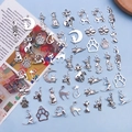 Flat lay of antique silver cat and paw alloy charms on a blue background for DIY jewelry - 17 Styles Cat Pendants Mixed 51 Pieces (SN76)