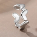 Vista detallada de un anillo de acero inoxidable plateado con diseño de corazones huecos - Estilo de Corazón Hueco (40156-2 Plateado) / Plateado