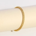 Detail of a gold stainless steel tubular segmented bracelet with a polished mirror finish - Gold Ribbed Textured Bangle (NU12-9)