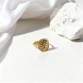 Detalle de anillo dorado vintage con grabado de sol sobre tela de seda blanca pura - Dorado (40409-1)