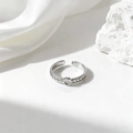 Detalle de un anillo ajustable plateado con textura trenzada y engaste de bisel redondo - Plateado (40463-2)