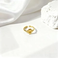 Detalle de un anillo ajustable dorado con una flor de trébol en 3D sobre fondo de seda - Diseño de Trébol de Cuatro Hojas - Oro (40183-1 Oro)