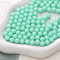 Losse muntgroene ronde plastic kralen voor DIY sieraden en handwerk op een wit dienblad - Groen