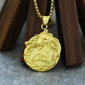 Detalle de cerca del colgante de dragón vikingo dorado con nudo celta en soporte madera - Colgante Color Oro