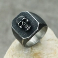 Macro shot of a 3D skull punk ring on stone with vintage oxidized stainless steel finish - Antique Color
