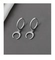 Vue détaillée de boucles d'oreilles créoles lune argentées sur fond texturé foncé - Or blanc