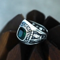 Close-up of vintage steel class ring featuring green gemstone and eagle relief carvings - Silver Green Gemstone