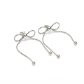Close-up of bow-shaped dangling earrings with snake chains and silver tassels - Steel Color Earrings