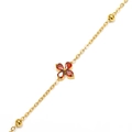 Macro detail of gold clover bracelet with four red pear-cut gems and beaded chain link - Gold Red Zirconia