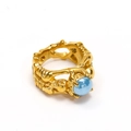 Macro detail of skull-style punk ring with gold texture and blue ceramic stone inlay - Gold Light Blue Ceramic
