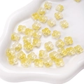 DIY handmade bead components with gradient yellow flower shape in a white ceramic dish - Yellow