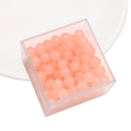 Sferische perzikroze glazen kralen in een doorzichtige vierkante plastic doos - Abrikoos