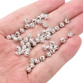 Perles intercalaires fleur argentées pour bijoux DIY présentées dans la main - Perles d'Escargot 4x5mm (Ouverture 1mm) / Argent (environ 25 Pièces/Paquet)
