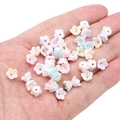 Perles en forme de fleur aux tons pastels présentées sur la main pour création de bijoux - 8x4mm (Environ 100 Pièces/Paquet) / Muguet Mabe Mélange Aléatoire
