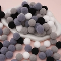 Mix of black and grey plush polyester pom poms displayed on a ceramic tray for DIY crafts - 50 Pieces / 2cm / Black & White Series