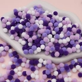 Mix of purple and white plush pom poms in a cloud tray for DIY Christmas crafts - Pack of 200 / 0.8cm / Purple Series