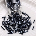 Deep black metallic bugle beads poured onto a white relief porcelain plate for DIY jewelry - Spiral Bugle Beads (#08)