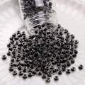 Translucent dark gray glass seed beads for DIY jewelry making poured on a white plate - Ink Dyed Round Beads (#13)