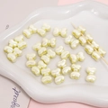 Chic pearlescent cream bow beads for DIY jewelry making displayed on a ceramic tray - 2 Pieces/Pack (15×11mm) / Yellow