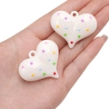 Hand holding white acrylic heart pendants with colorful polka dots for DIY jewelry making - Heart (44x35mm)
