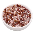 Mix of red, pink, and caramel glass seed beads in a ceramic bowl for DIY jewelry making - Dark Coffee