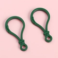 Deux crochets porte-clés en plastique vert foncé en forme de gourde sur fond rose - Vert clair