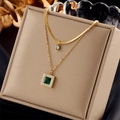 Collana a strati in titanio dorato con ciondolo smeraldo e cristallo bianco su espositore - Collana