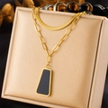 Nahaufnahme von goldenem Schmuckset mit schwarzem Emaille-Anhänger und feinen Kettenstrukturen - Trapezförmige Schwarze Plakette Halskette