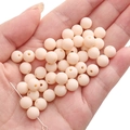 DIY beige matte acrylic round beads for handmade jewelry making on a palm display - Skin Pink