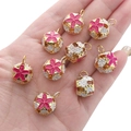 Colorful floral cloisonné bell pendants in gold, pink, and white enamel on a palm - Rose Red