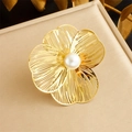 Macro shot of gold floral brooch with hollow petals and a white pearl on metal lid - Hollow Petal Pearl Style (R485)
