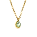 Détail d'un collier doré avec pendentif en zircone verte taille poire sur fond blanc pur - Or Pierre Vert Eau
