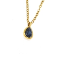Gros plan d'un pendentif en zircon bleu en forme de poire sur une chaîne dorée - Or Gemme Bleu Encre