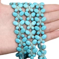Macro detail of sky blue butterfly-shaped turquoise beads with natural brown iron veins - Butterfly (15x20mm)