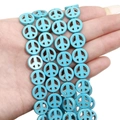 Hand holding turquoise blue peace sign beads with natural black veins for jewelry making - Peace Sign (12mm)