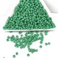Perles de rocaille en verre vert menthe dans un plateau blanc pour création bijoux - Vert