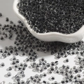 Translucent black-grey 2-4mm glass seed beads for DIY jewelry making in a white shell bowl - Black