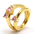 Dettaglio di tre zirconi rosa a forma di cuore su un anello in acciaio inossidabile dorato - Oro Zircone Rosa