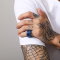 Nahaufnahme eines dunkelblauen Metallrings im Industrial-Stil am Finger eines Mannes - Blau