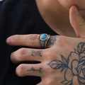 Vista macro de anillo punk para hombre con piedra turquesa y texturas de pluma - Dorado-Plateado Turquesa