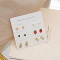 Close-up of 6 pairs of fruit-themed stud earrings on a weekly card presentation - Strawberry Bow Orange Juice Cup Pearl Zirconia Cactus