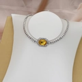 Detalle de una pulsera tenis con una gema amarilla rectangular y halo de diamantes - Estilo Cristal Amarillo