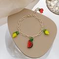 Detalle de la pulsera de eslabones dorados con dijes coloridos de sandía y limón - Pulsera de Frutas