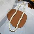 Detail shot of 8mm cream glass pearls with golden lobster clasp and extension chain - 10mm Style