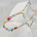 Detalle de collar de cuentas de colores con flores y perlas sobre tela blanca fina - Estilo de Flores de Cuentas Coloridas (JXJL-58)