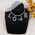 Primer plano detallado del colgante LOVE de diamantes de imitación en gargantilla de plata - Estilo Plateado