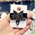 Dettaglio dell'elastico nero con grande ciondolo a stella dorata e cristalli - Cristallo Grigio Nero